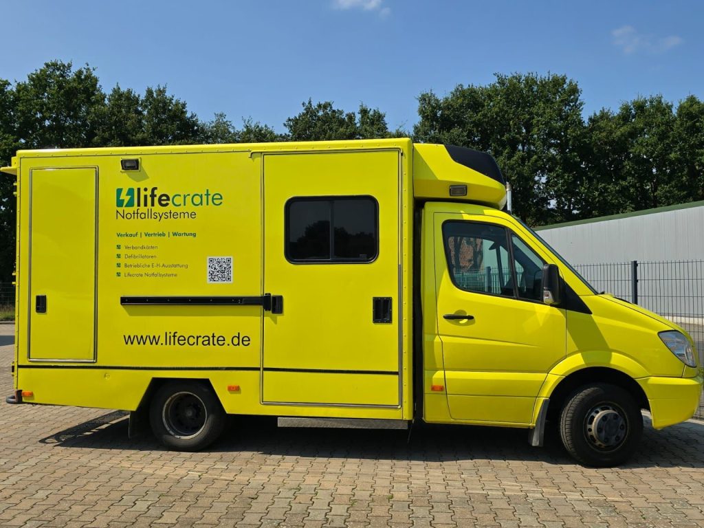 Ein gelber Krankenwagen steht auf einer Ziegelstraße und ist bereit für einen Notfalleinsatz im städtischen Umfeld.